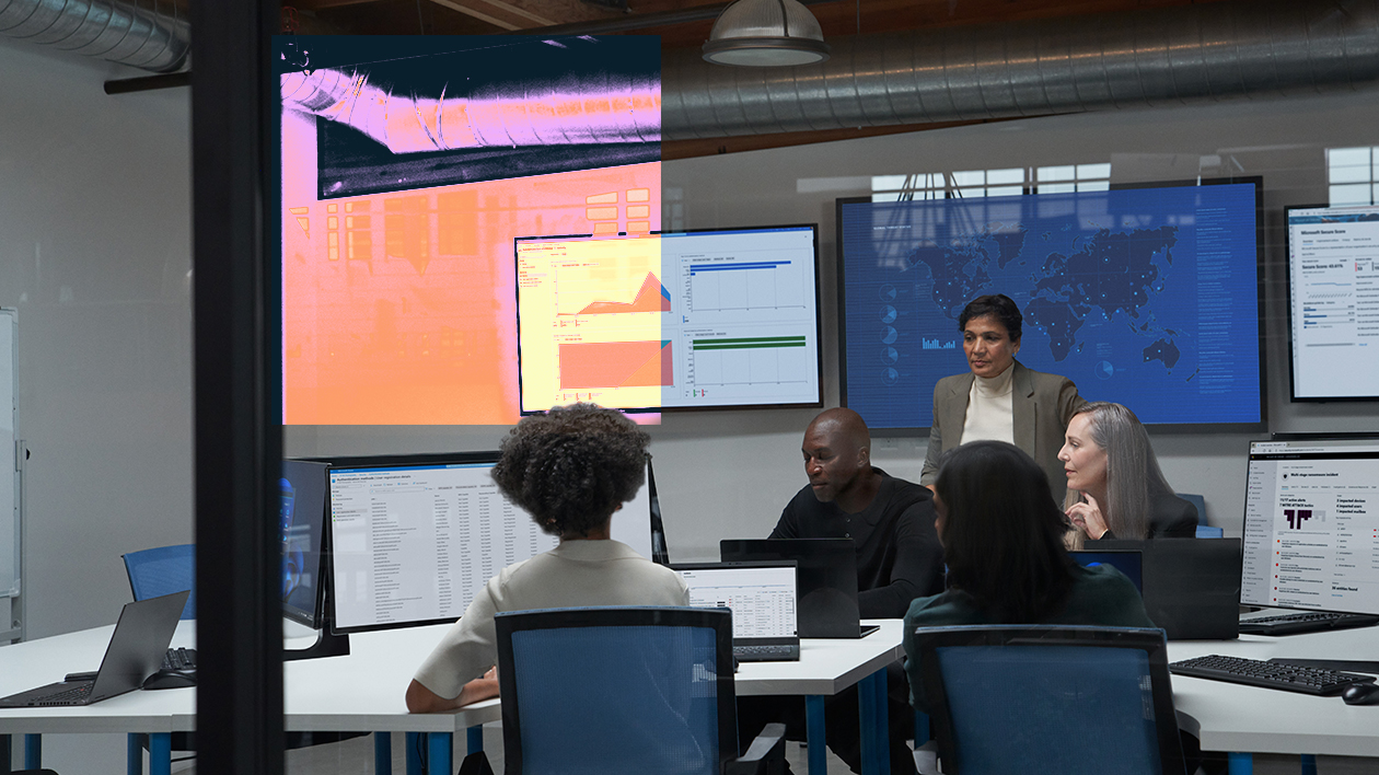 A group of people sitting around a table with computers