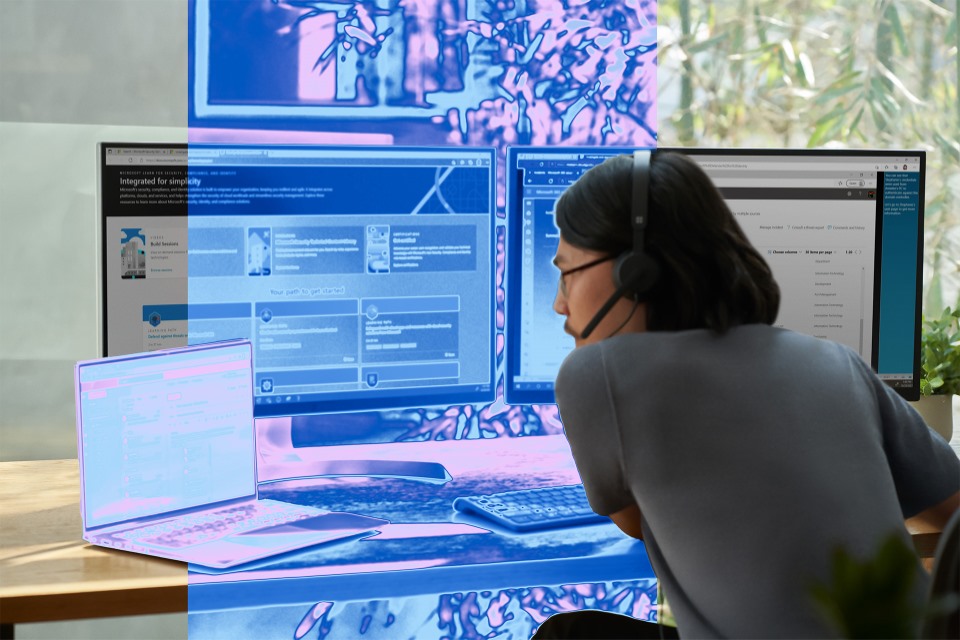 A security practitioner sits at a computer