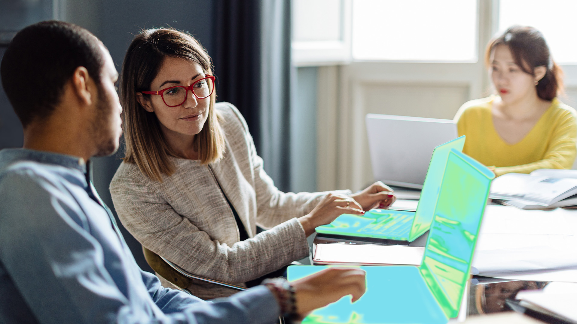 Two security practitioners collaborate over two laptop computers