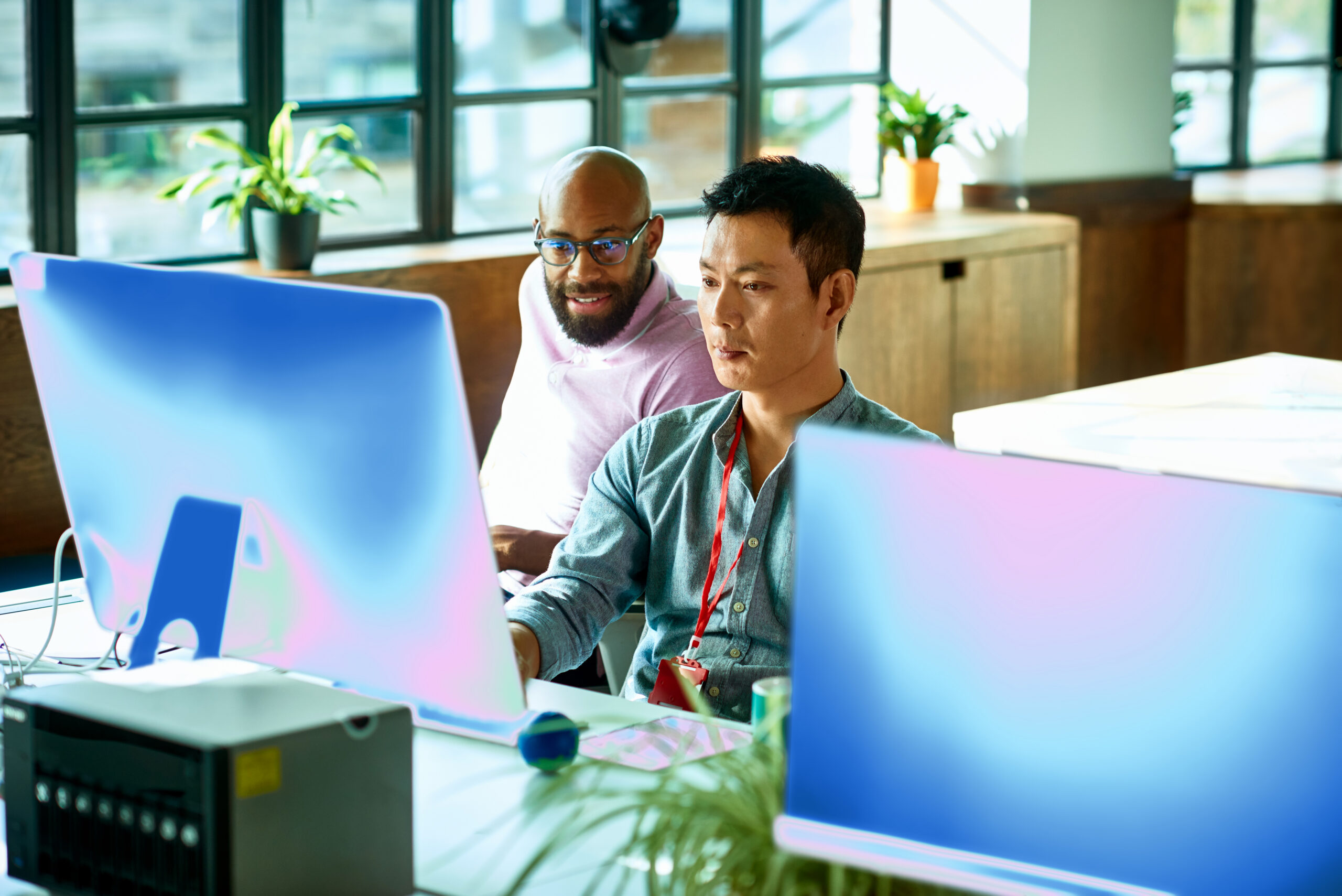 Two security practitioners look at a computer screen together