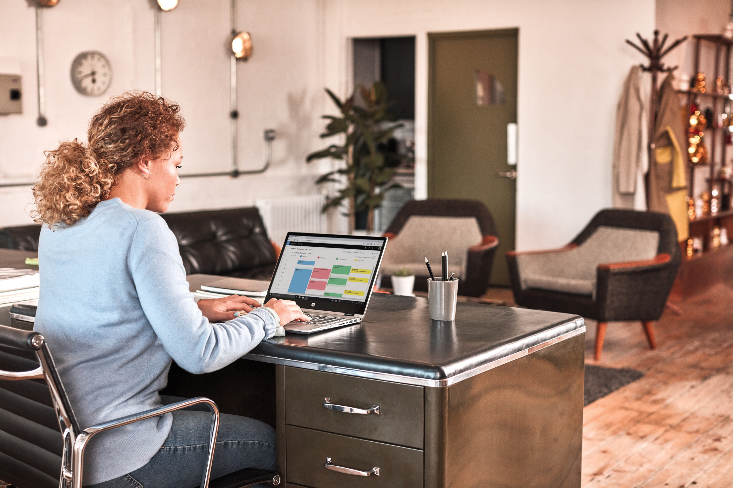 a person sitting at a table using a laptop