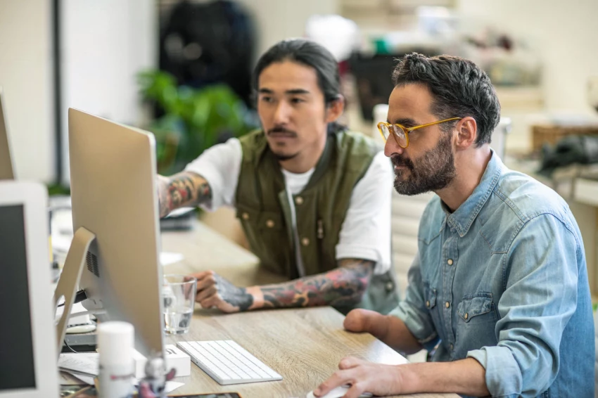 People working on computer at desk.