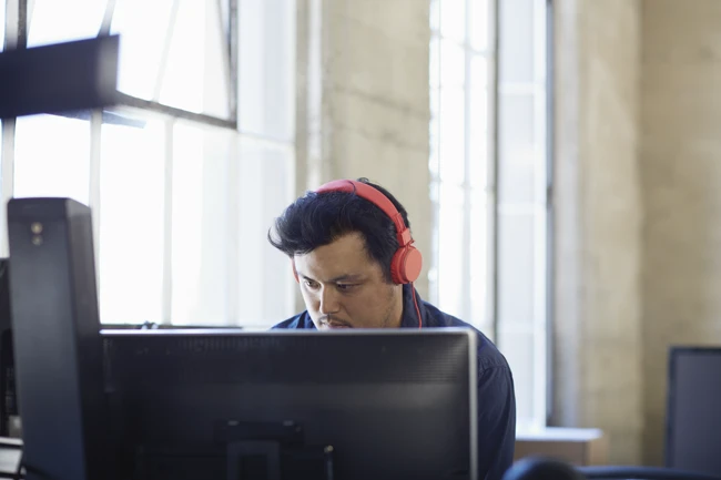 Man with headphones watching monitor