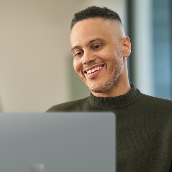 Person smiling while working on computer.