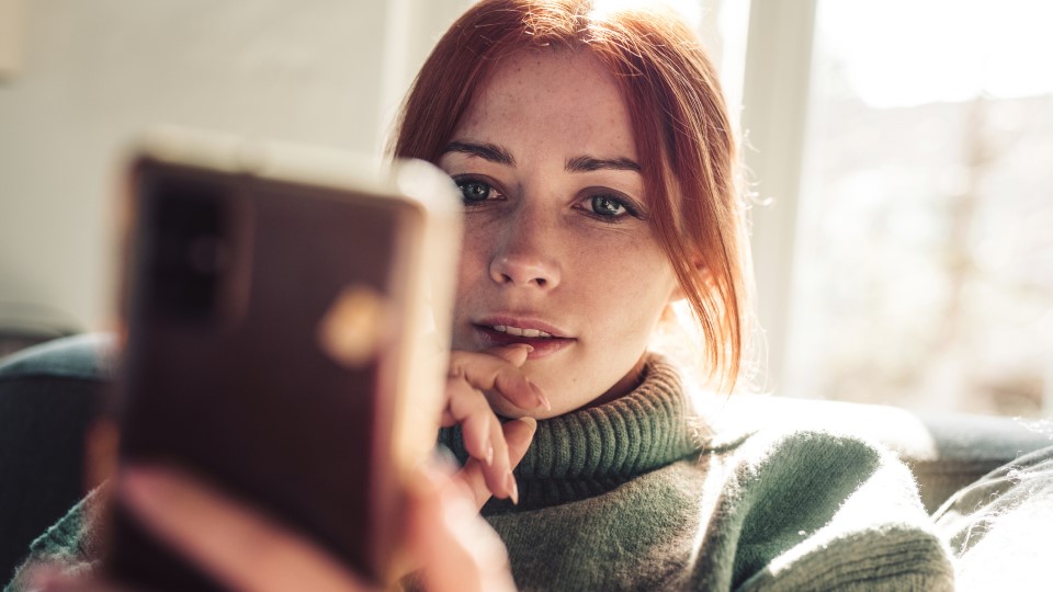 A woman looks at her phone