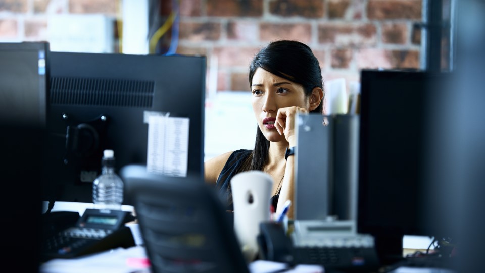 A woman stares worriedly at her compurer