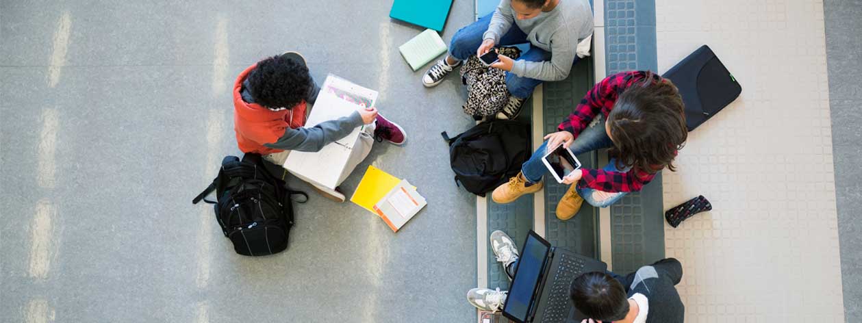 Widok z lotu ptaka grupy studentów studiujących laptopy, tablety i smartfony